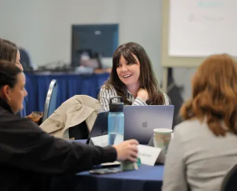 woman talks with a group of CDME students