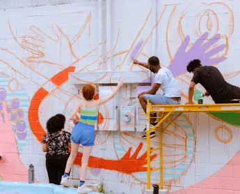 artists paint a colorful mural