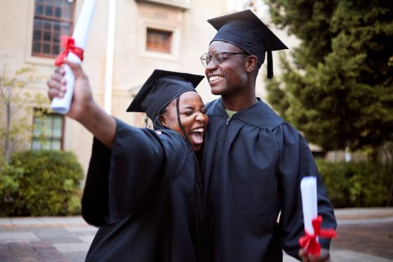 two black graduates celebrating their graduation