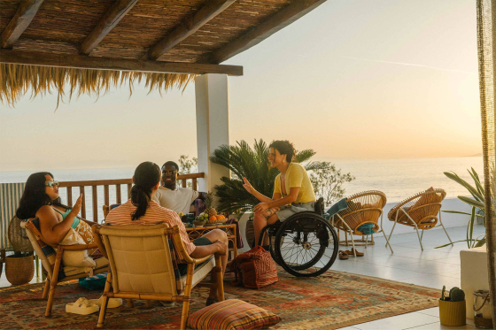 group of friends gathered around a table at sunset