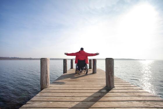 Man in wheelchair admiring view of lake