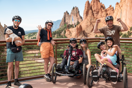 travelers posing in front of red rocks