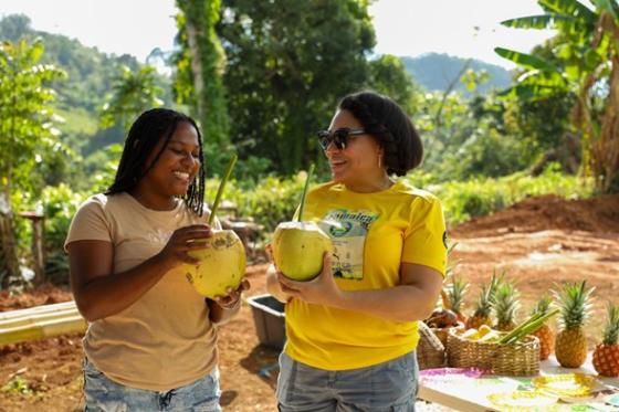 two women holding coconuts