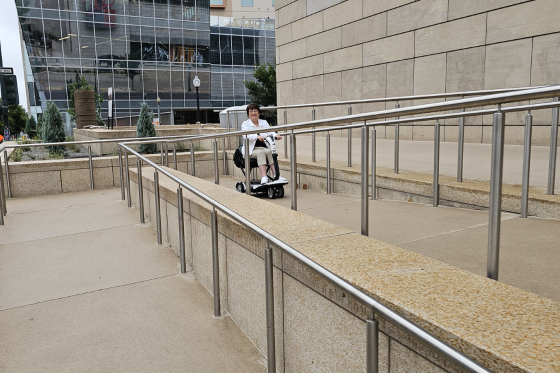 wheelchair user accessing a ramp to a building