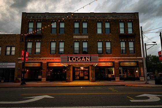 a building with its lights on. The sign says "LOGAN" in large letters
