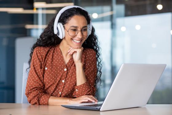 woman wearing headphones watching something on her computer
