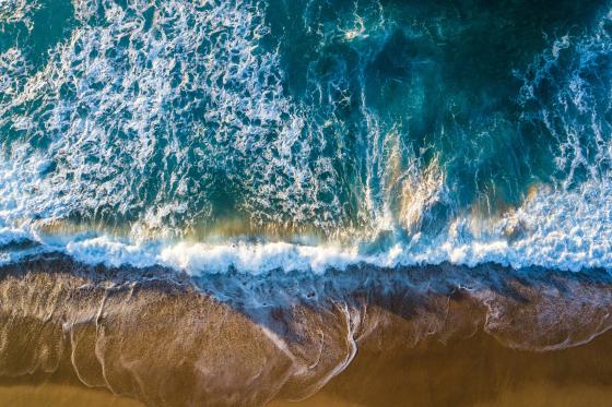 greenish blue ocean waves hitting the shore at the beach