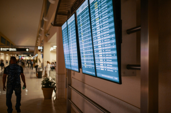 digital screen hanging on the wall in an airport