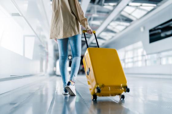 woman walking in airport with suitcase