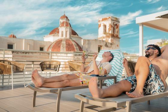 2 men tanning on lounge chairs