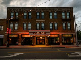a building with its lights on. The sign says "LOGAN" in large letters