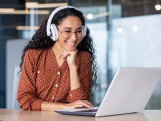 woman wearing headphones watching something on her computer