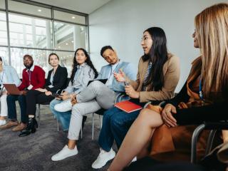 group of coworkers looking at their colleague who is speaking