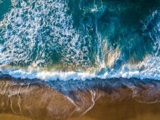 greenish blue ocean waves hitting the shore at the beach