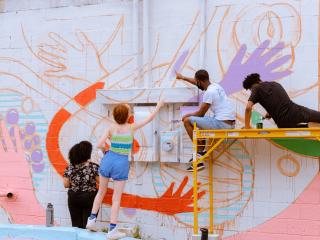 artists paint a colorful mural