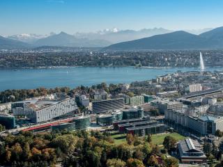 View of Geneva with city in foreground and water and mountains in background