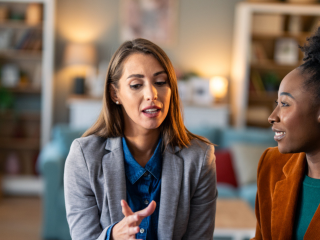 two women speak at work