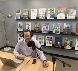Adam Stoker in conference room recording podcast