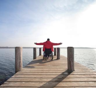 Man in wheelchair admiring view of lake