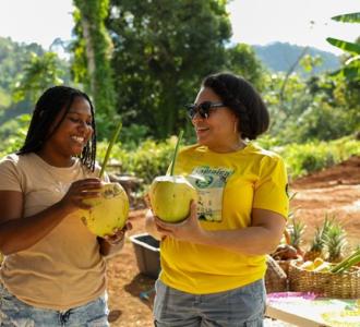 two women holding coconuts