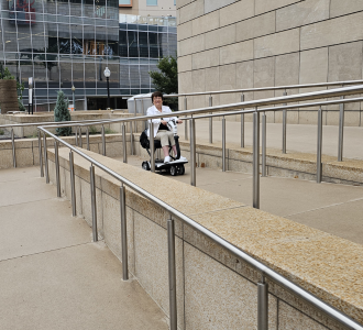 wheelchair user accessing a ramp to a building