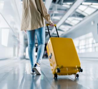 woman walking in airport with suitcase