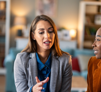 two women speak at work