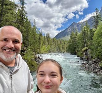 man and child in front of mountain view